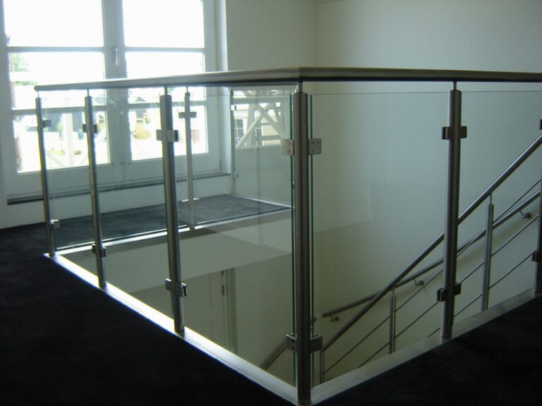 zwevende trap,houten trap,moderne trap,RVS,glas,Goeree-Overflakkee,Nederland,zicht op de balustrade op de overloop met RVS (roestvrij staal, inox) en glazen wandpanelen
